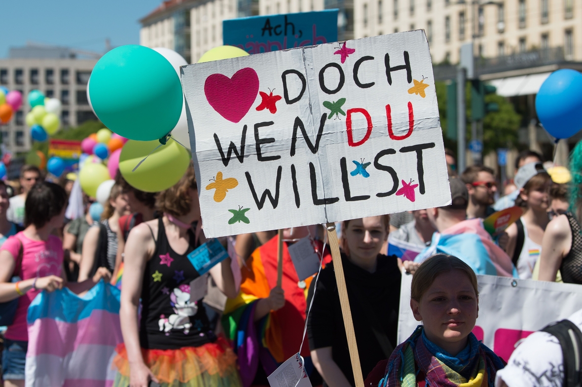 Teilnehmende beim Christopher Street Day in Dresden demonstrieren für gleiche Rechte und Toleranz für homosexuelle und queere Menschen. Auf einem Plakat steht: ♥️ doch wen du willst