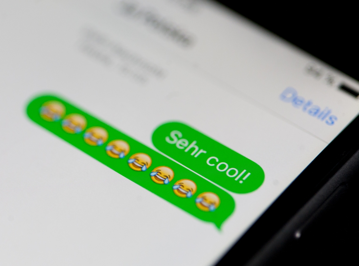 Lachende Smileys und Emojis werden auf dem Display eines Smartphones gezeigt