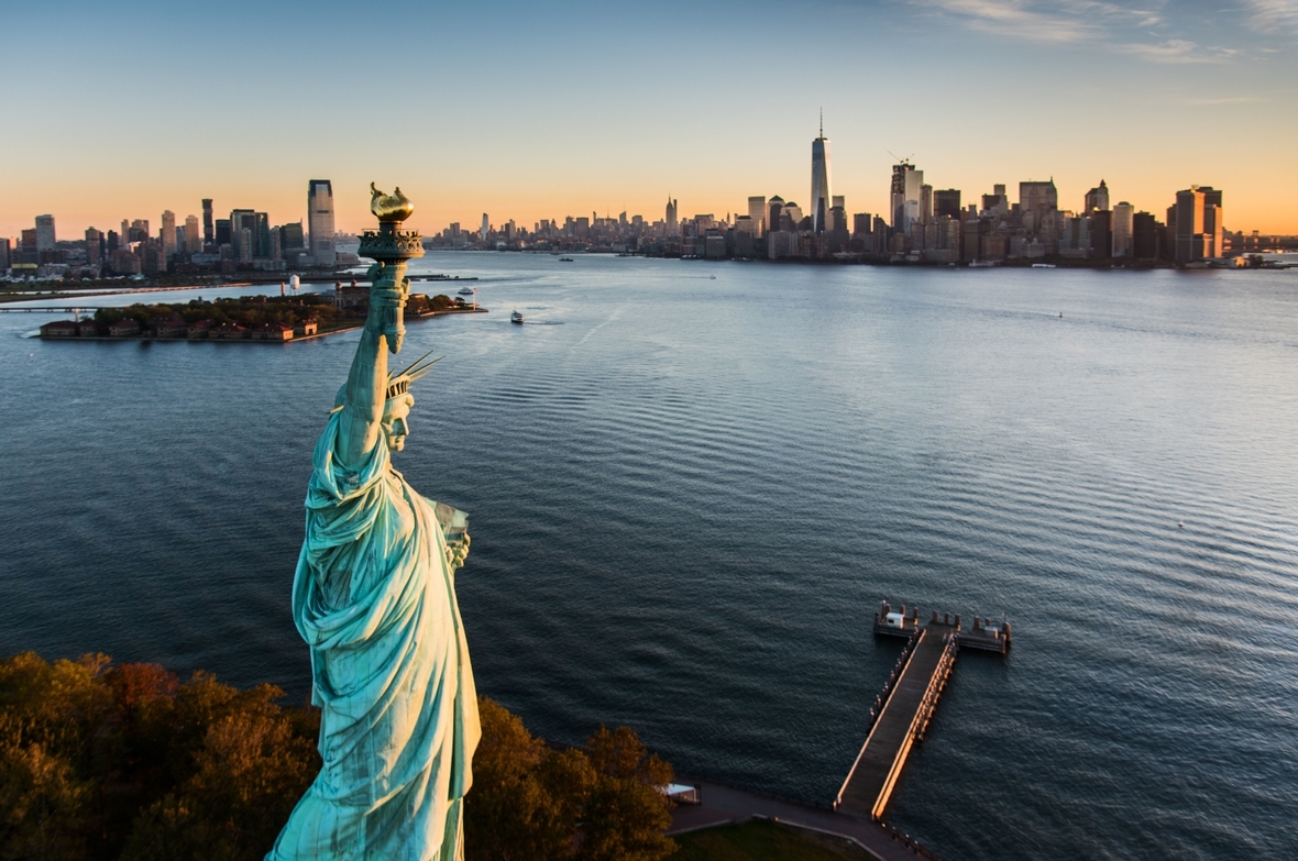 Die Freiheitsstatue mit der Stadt New York (USA) im Hintergrund