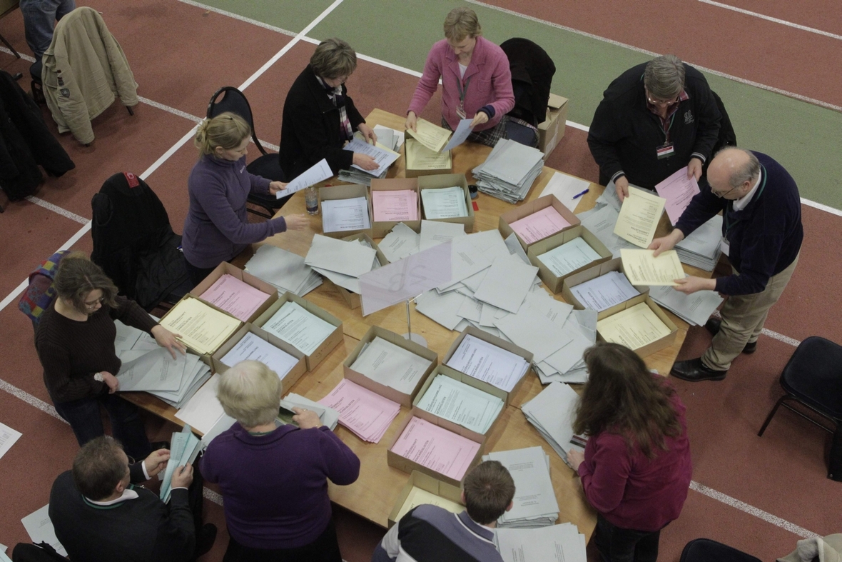 Wahlhelfer/innen zählen die Stimmen nach Schließung der Wahllokale aus.