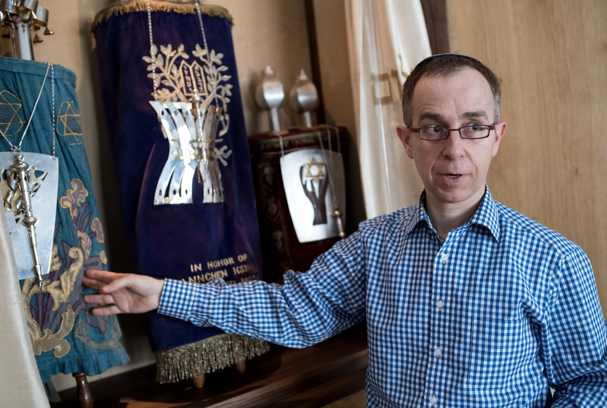 Ein Rabbiner steht vor einem Toraschrein, in dem die Torarollen aufbewahrt werden.