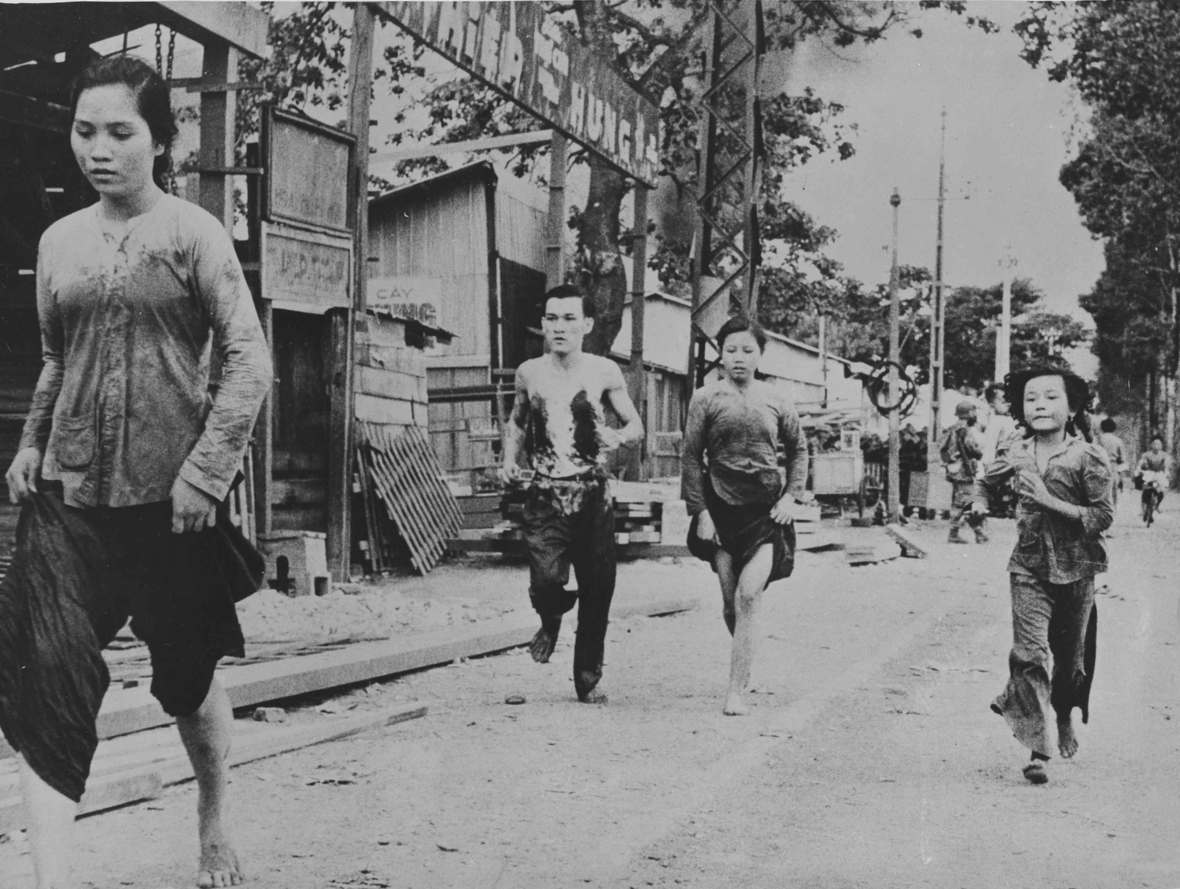 Ho-Chi-Minh-Stadt (früher bekannt als Saigon) im Jahr 1955: Menschen fliehen vor kriegerischen Angriffen. Erwachsene und Kinder laufen auf einer Straße.