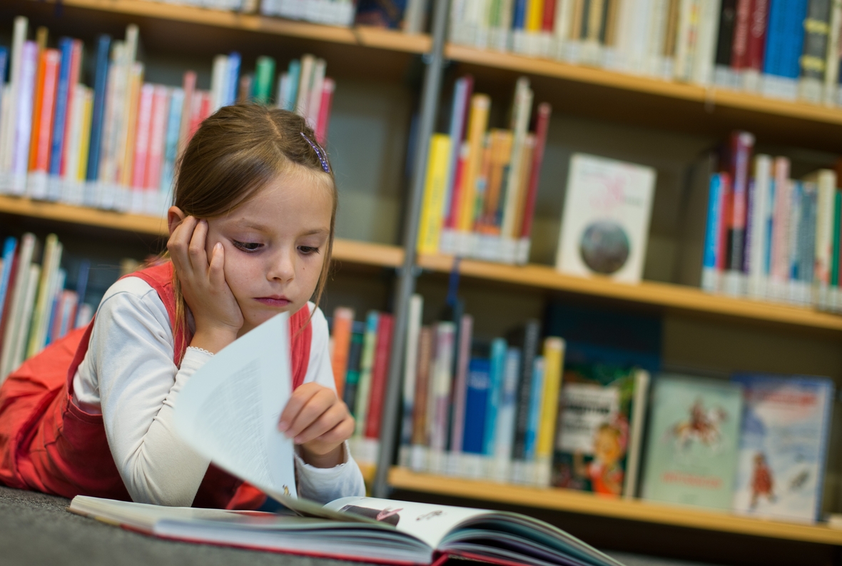 Lesen macht Spaß: Ein Mädchen Amy schaut sich in der Kinderbibliothek in Frankfurt (Oder) ein Buch an.