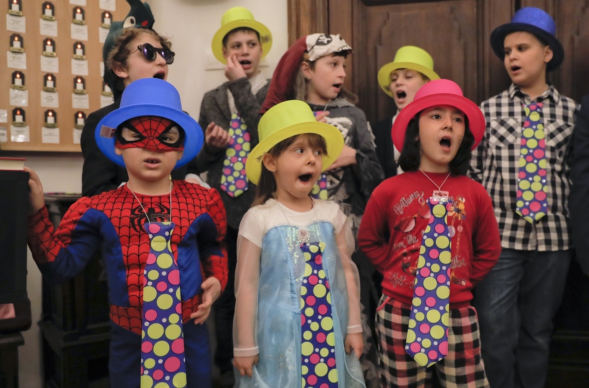 Kinder in Bukarest, Rumänien feiern Purim. Sie tragen lustige Kleider und üben hier Lieder, die sie zu Purim singen wollen.