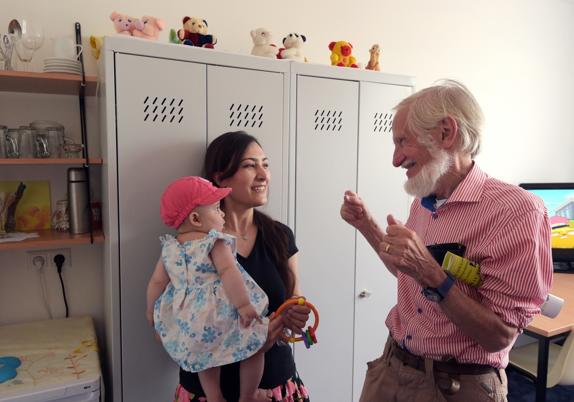Rupert Neudeck spricht im  Juli 2015 in Berlin im Rahmen der Eröffnung der Flüchtlingsunterkunft mit dem Namen "Rupert-Neudeck-Haus" mit einer Mutter mit Kind. Sie sind aus Afghanistan geflüchtet.
