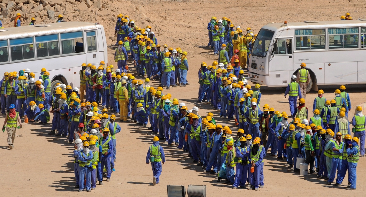 Viele ausländische Arbeiter werden auf den Baustellen in Katar ausgebeutet. Hier stellen sie sich auf, um in Bussen von ihren Sammelunterkünften zu den Arbeitsplätzen gefahren zu werden.