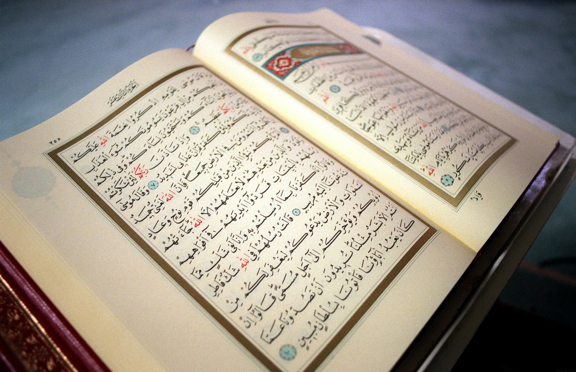 Ein aufgeschlagener Koran mit handgeschriebenen Texten. Die Kapitel des Koran nennt man "Suren".