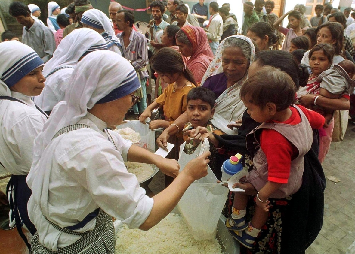 Kalkutta (Indien) Dezember 2000: Schwestern des Ordens "Missionarinnen der Nächstenliebe" verteilen Nahrungsmittel an Arme und ihre Kinder.
