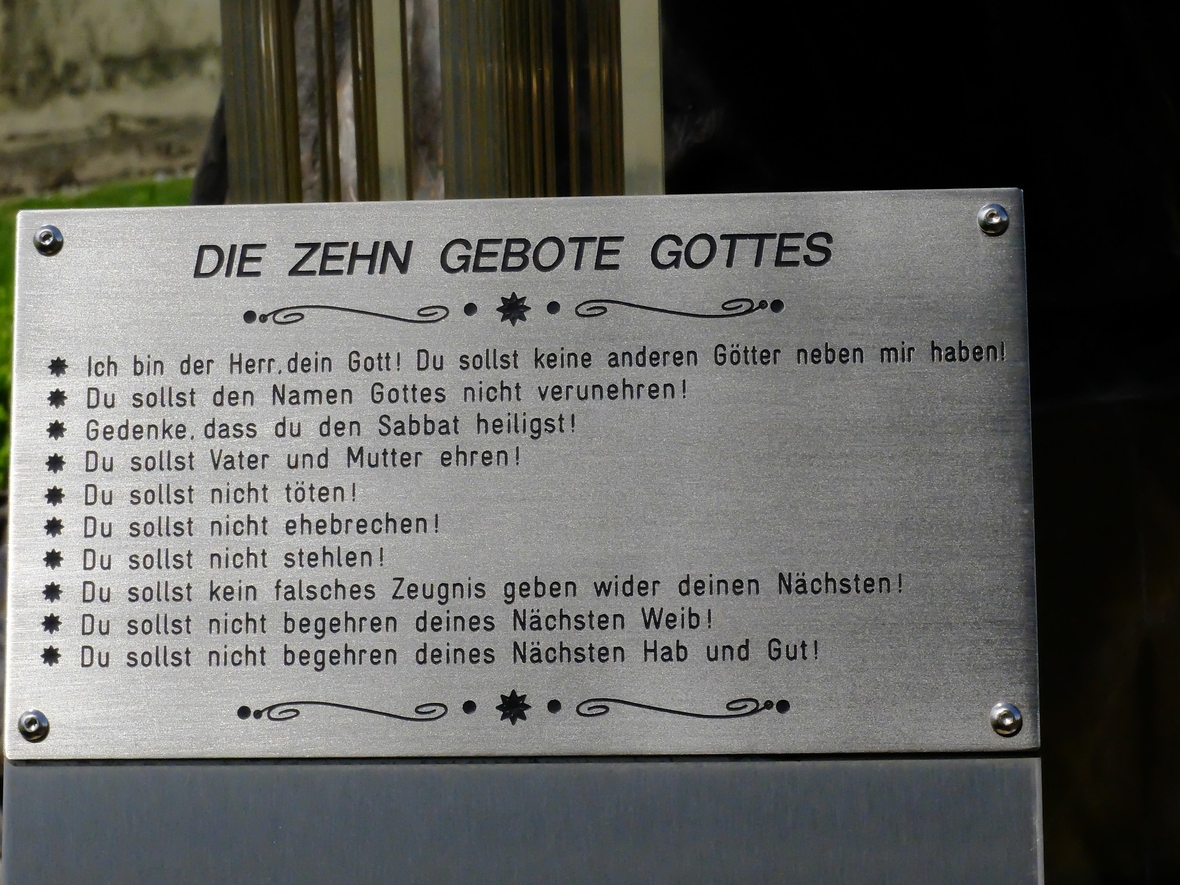 Eine Tafel im Schloss Altshausen, Bayern, nennt die Zehn Gebote. Sie ist unter einer Christusfigur angebracht.