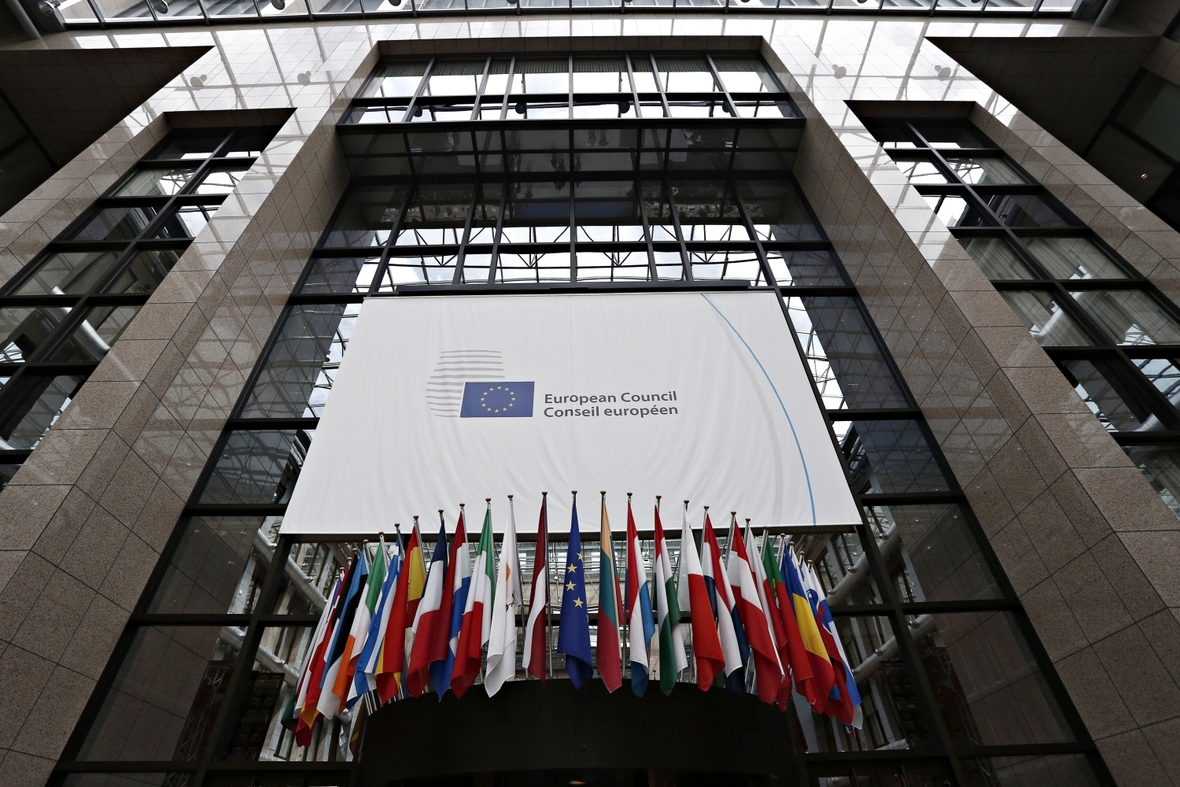 Das Gebäude des Europäischen Rats in Brüssel mit vielen Fahnen, die über dem Eingang hängen.