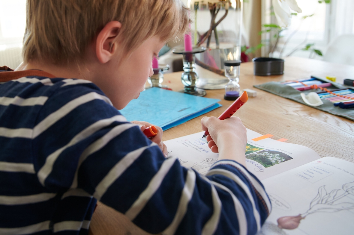 Wenn die Schule wegen Corona nicht auf hat, muss man zuhause lernen. Kind beim Homeschooling am Esstisch