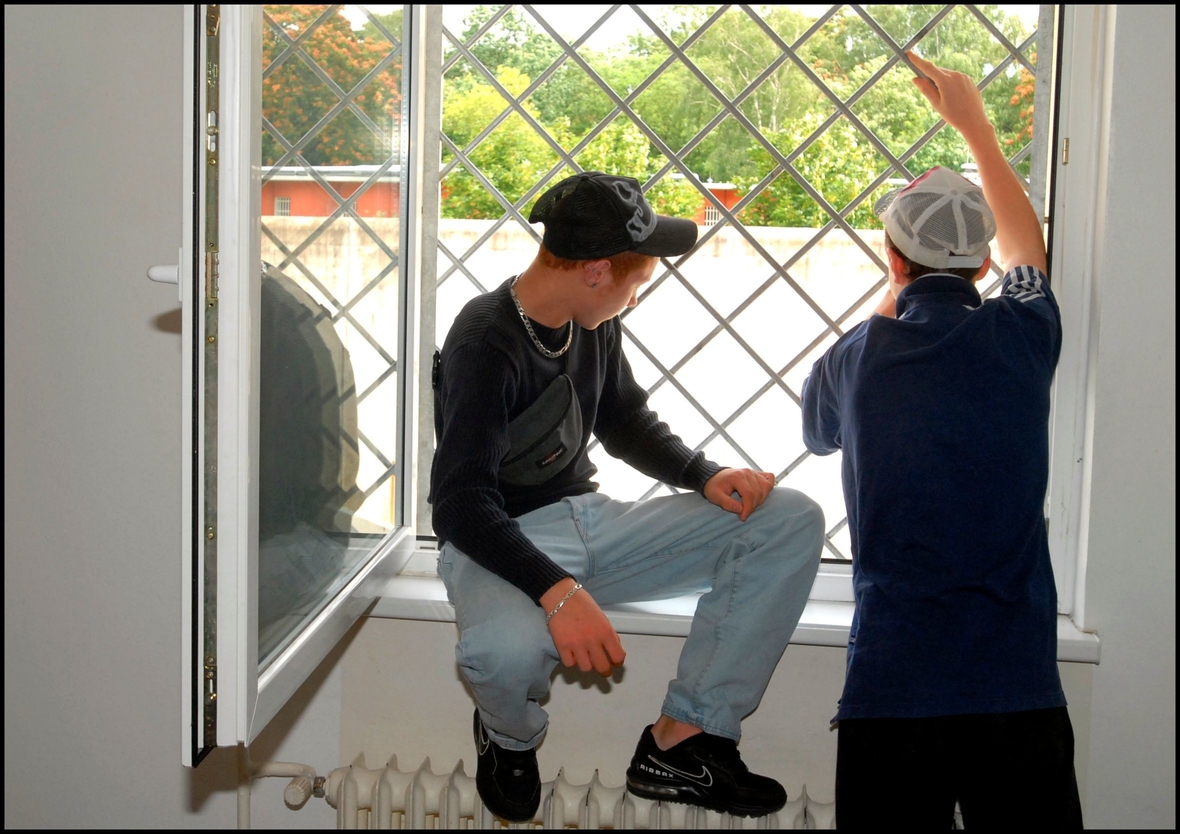 Jugendarrestanstalt in Berlin Lichtenrade,  Jugendliche stehen vor einem vergitterten Fenster in einer Jugendarrestanstalt. Die straffällig gewordenen Jugendlichen stehen hier zwischen zwei Tagen und vier Wochen unter Arrest, verstanden als Erziehungsmaßnahme, nicht als Strafe. 