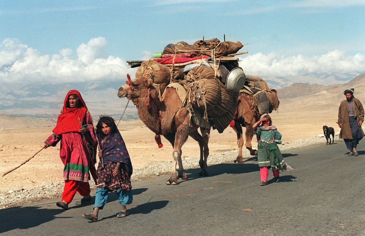 Nomaden-Familie mit ihrem beladenen Kamel zieht vom Norden in den Süden Afghanistans. Nomaden haben keinen festen Wohnsitz. Sie ziehen umher und bauen ihr Zelt dort auf, wo sie für ihre Tiere gute Weideplätze finden.