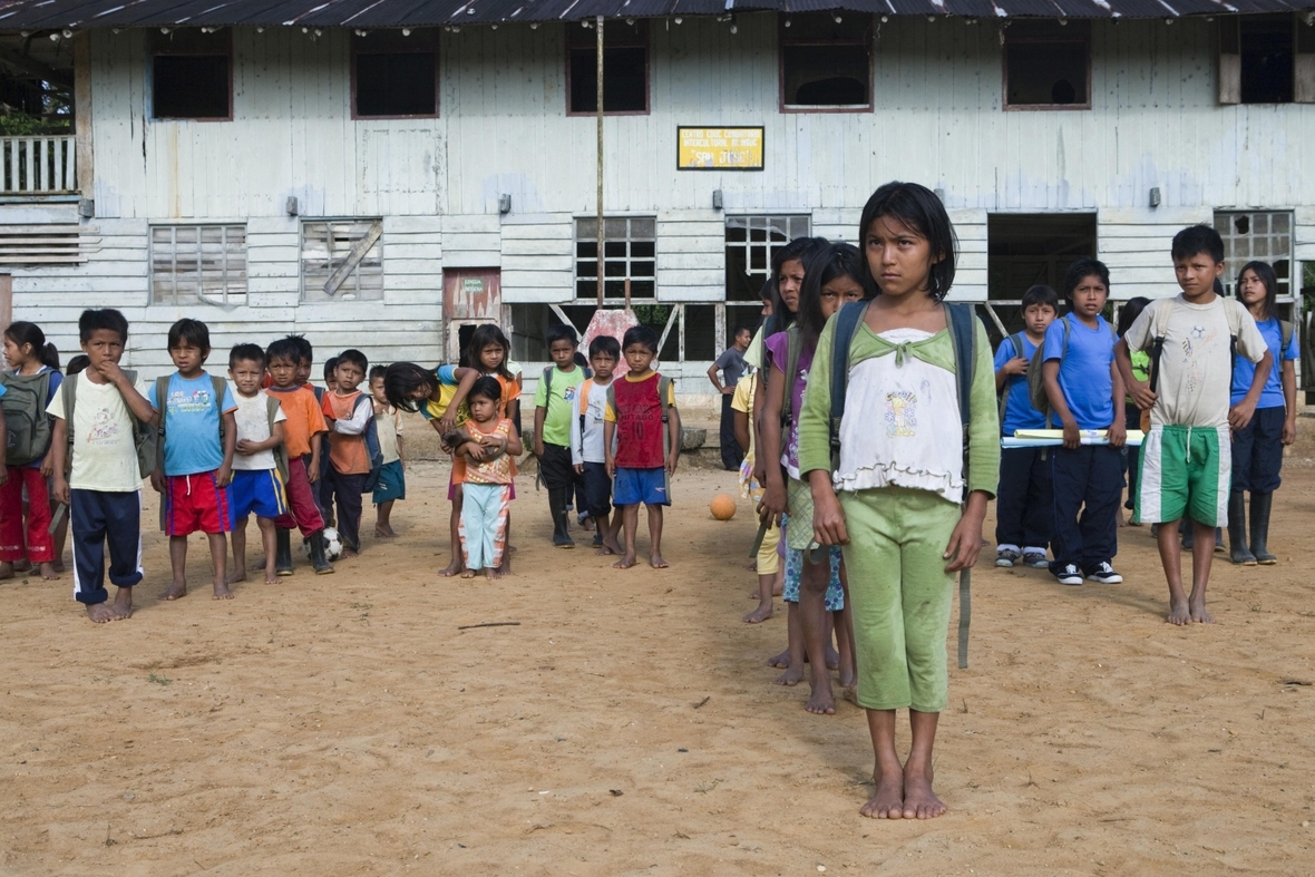 Vor dem Unterricht stellen sich die Schulkinder auf dem Schulhof auf. Die Schule befindet im Regenwald von Ecuador.