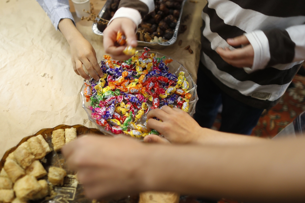 Besonders die Kinder lieben die Süßigkeiten, die es am Ende des Fastenmonats Ramadan gibt. Hier greifen kleine Hände in Bonbon-Schalen.
