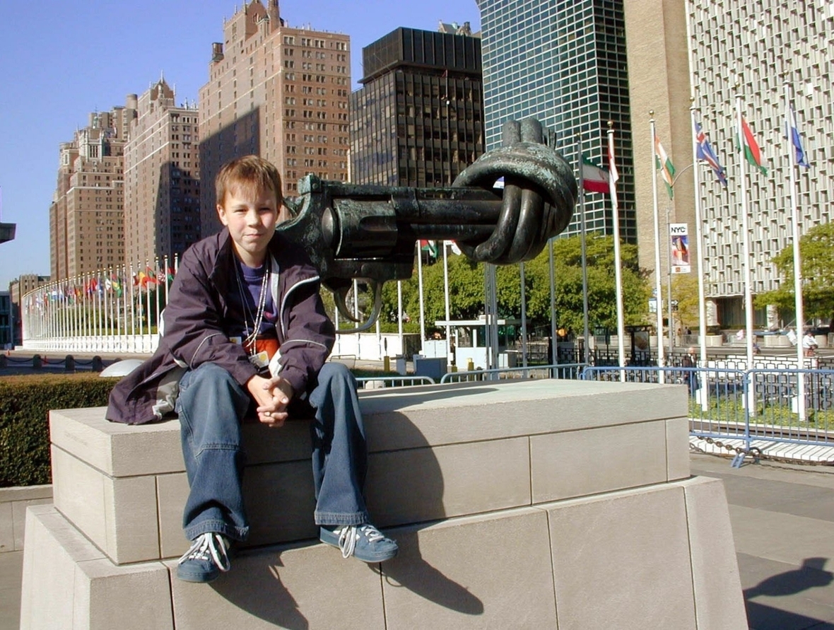 Mai 2002: Der 10-jährige Marian Brehmer nimmt für Deutschland beim 2. Weltkindergipfel in New York teil.  Er sitzt neben dem berühmten Denkmal gegen Waffengewalt, das im Garten des UN-Hauptquartiers steht.