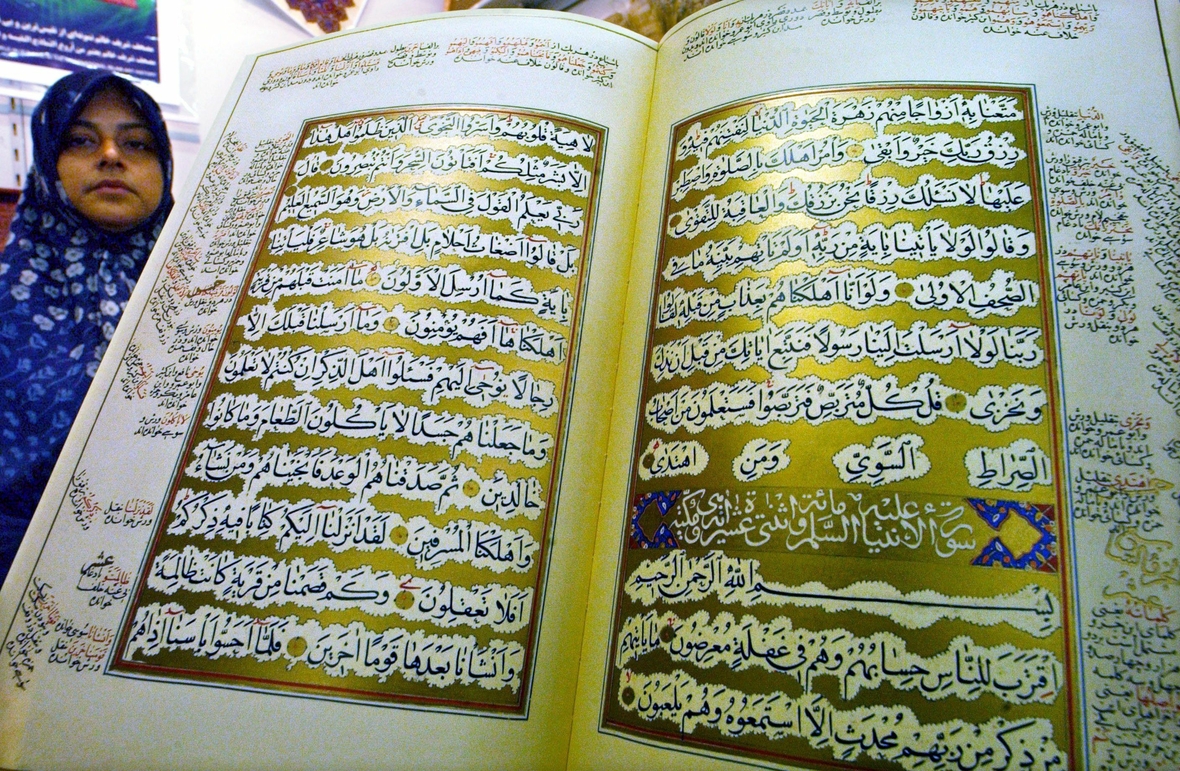 Eine kunstvoll gestaltete Ausgabe des Koran. Auf goldenem Untergrund sind die Schriftzeichen geschrieben.