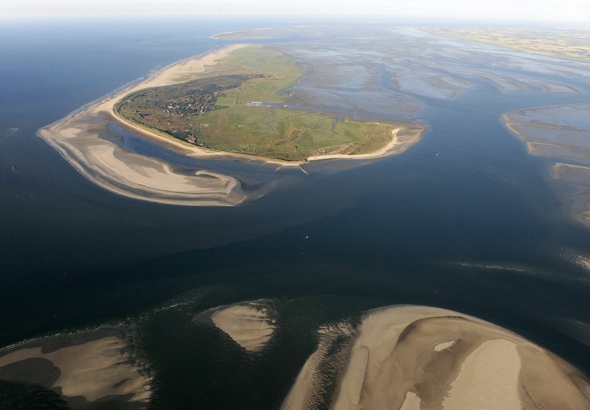 Die Luftaufnahme zeigt die ostfriesische Insel Spiekeroog (Niedersachsen) im Nationalpark Niedersächsisches Wattenmeer. Ganz weit im Hintergrund ist Wangerooge zu erkennen. Im Vordergrund ist die Spitze der Insel Langeoog zu sehen.