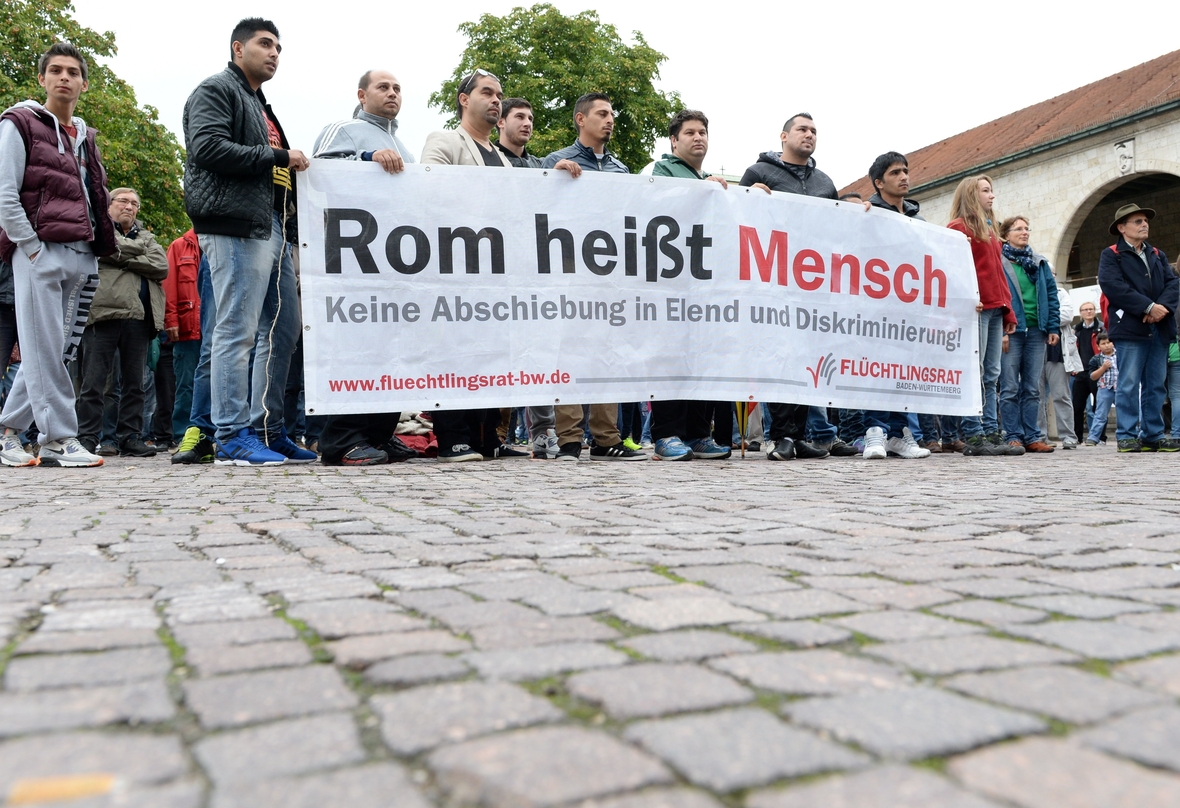 Sinti und Roma bei einer Demonstration. Rom heißt Mensch steht auf dem großen Plakat. Die Demonstranten wenden sich gegen eine Änderung des Asylrechts im Jahr 2014