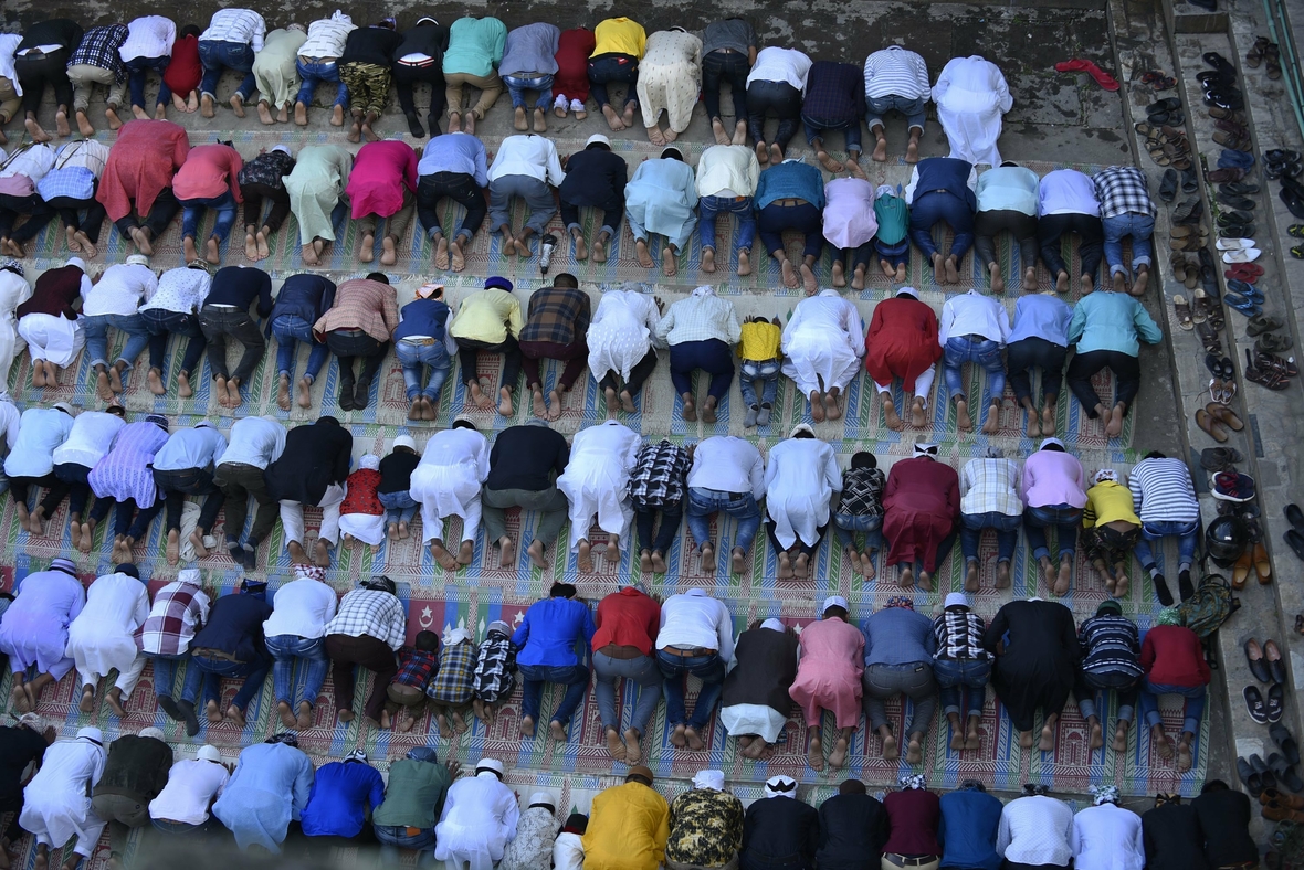 Muslime beten in einer Moschee in Kathmandu, Nepal. Die Männer beugen kniend ihre ihre Rücken.