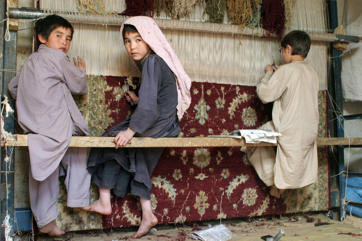 Kinder knüpfen in Afghanistan Teppiche, um das Einkommen der Familie zu verbessern.