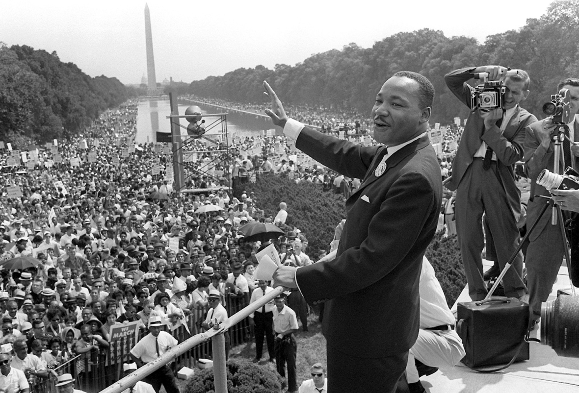 28.08.1963: Der US-Bürgerrechtler Martin Luther King winkt bei einer Kundgebung von der Lincoln-Gedächtnisstätte in Washington aus seinen Anhängern zu. Im Hintergrund ist das Washington Monument zu sehen.