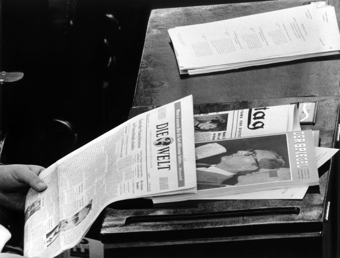 Ein Bundestagsabgeordneter hat am 07.11.1962 in Bonn während einer Bundestagssitzung über die Verlängerung der "Spiegel"-Debatte eine Ausgabe des Nachrichtenmagazins vor sich liegen während er eine Tageszeitung liest.
