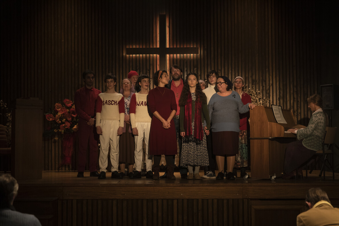 Ein Kirchenchor steht auf der Empore und singt ein Lied. 