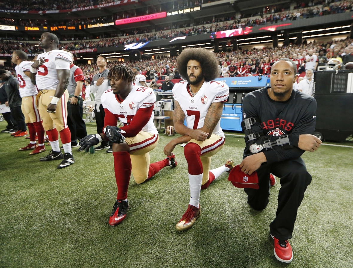 18. Dezember 2016: San Francisco 49ers Spieler Colin Kaepernick (mit der Nummer 7) und Eli Harold (mit der Nummer 58) knien während der Hymne nieder. In den USA erklingt vor den Spielen die Nationalhymne.