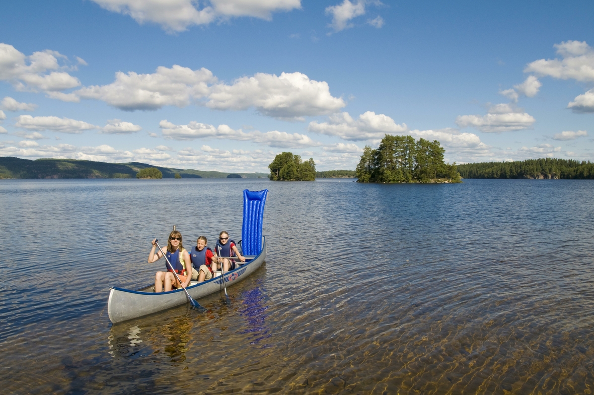 Eine Familie fährt Kanu auf einem See bei Bengtsfors im Norden der historischen Provinz Dalsland.