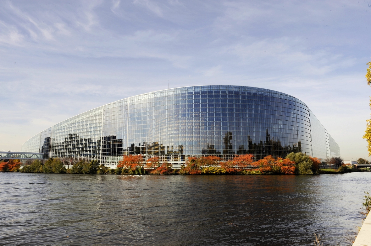 Das Europäische Parlament in Straßburg von außen betrachtet. Vor dem Parlament sieht man den Rhein fließen.