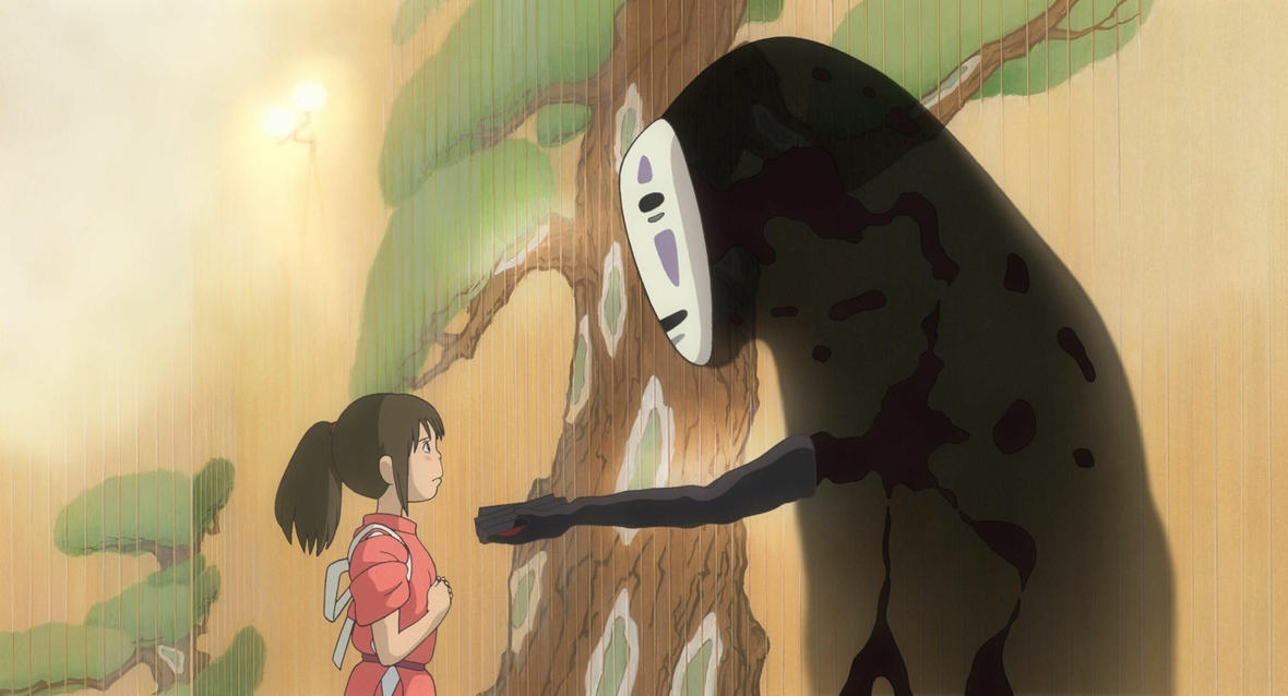 Szenenbild: Das große Gespenst Ohngesicht (links im Bild) überreicht der kleinen Chihiro, die keine Angst zeigt, ein Geschenk. 