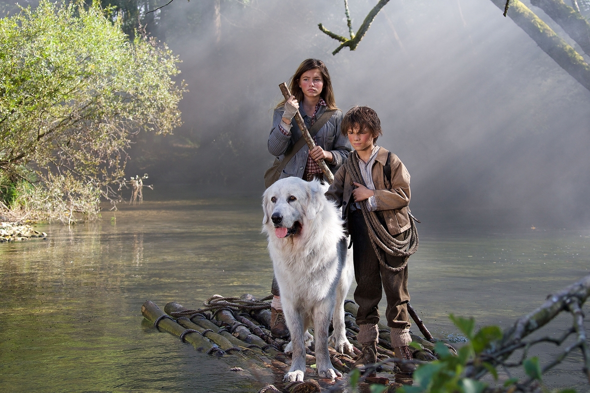 Szenenbild: Sebastian, rechts, und Gabriela auf der Hündin Belle sitzend, links, auf einem Floß mitten auf dem Fluss
