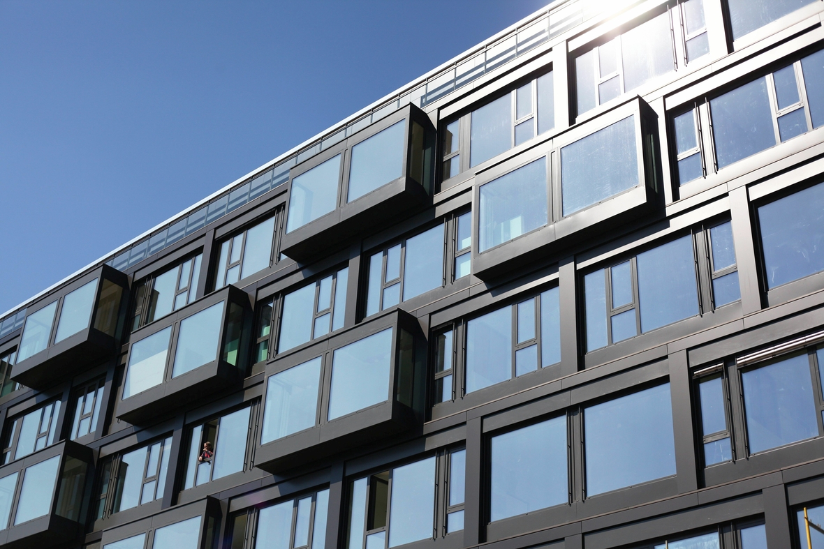 Luxuswohnungen in  Berlin - die Fassade zeigt große blanke Fensterscheiben in Metallrahmen