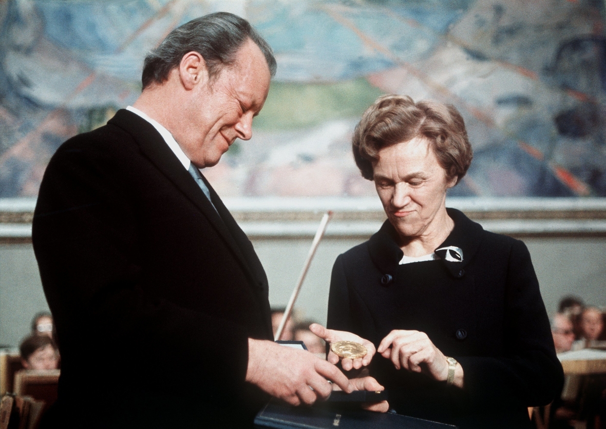 Die Vorsitzende des Nobelpreis-Komitees, Frau Aase Lionaes, überreicht dem deutschen Bundeskanzler Willy Brandt Urkunde und Medaille des Friedens-Nobelpreises. Aufgenommen am 10.12.1971 in der Aula der Universität von Oslo.