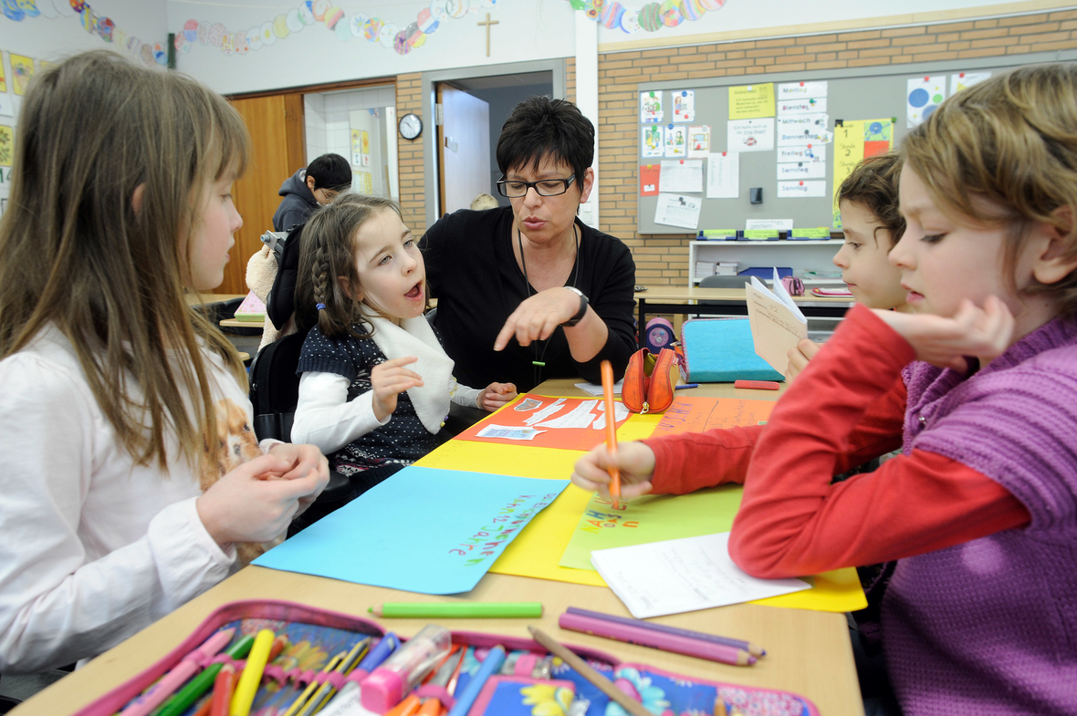 Eine behinderte Schülerin und eine Sonderpädagogin arbeiten in der St.-Konrad-Schule in Neuss mit anderen Schülern in einer Gruppe. Die Grundschule praktiziert das Lernen von behinderten und nichtbehinderten Kinder.