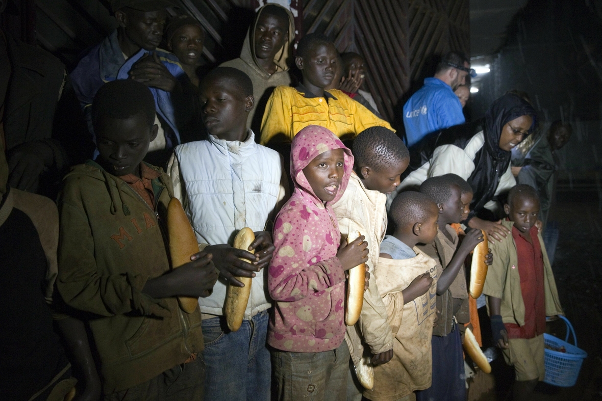Man sieht Straßenkinder in Burundi in Afrika. Sie warten auf die Verteilung von Lebensmitteln durch Sozialarbeiter einer NGO.