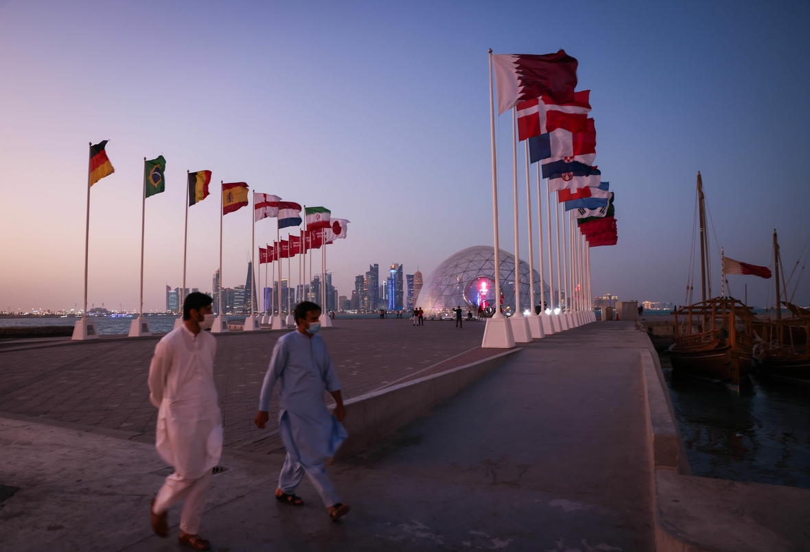 Flaggen der verschiedenen Teilnehmer-Nationen der WM 2022 sind in Doha zu sehen.  Dahinter erkennt man die Skyline der Hauptstadt.