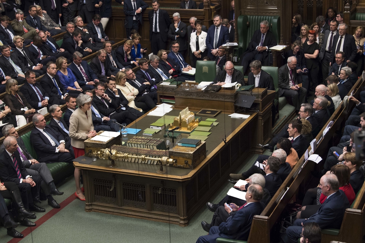 Im englischen Parlament sitzen sich Regierung (links) und Opposition (rechts) direkt gegenüber. Am Mikrofon steht Theresa May (konservative Partei) Premierministerin von 2016-2019. Ihr direkt gegenüber sitzen die Abgeordneten von Labour (Arbeiterpartei), die damals die Opposition gebildet haben. 