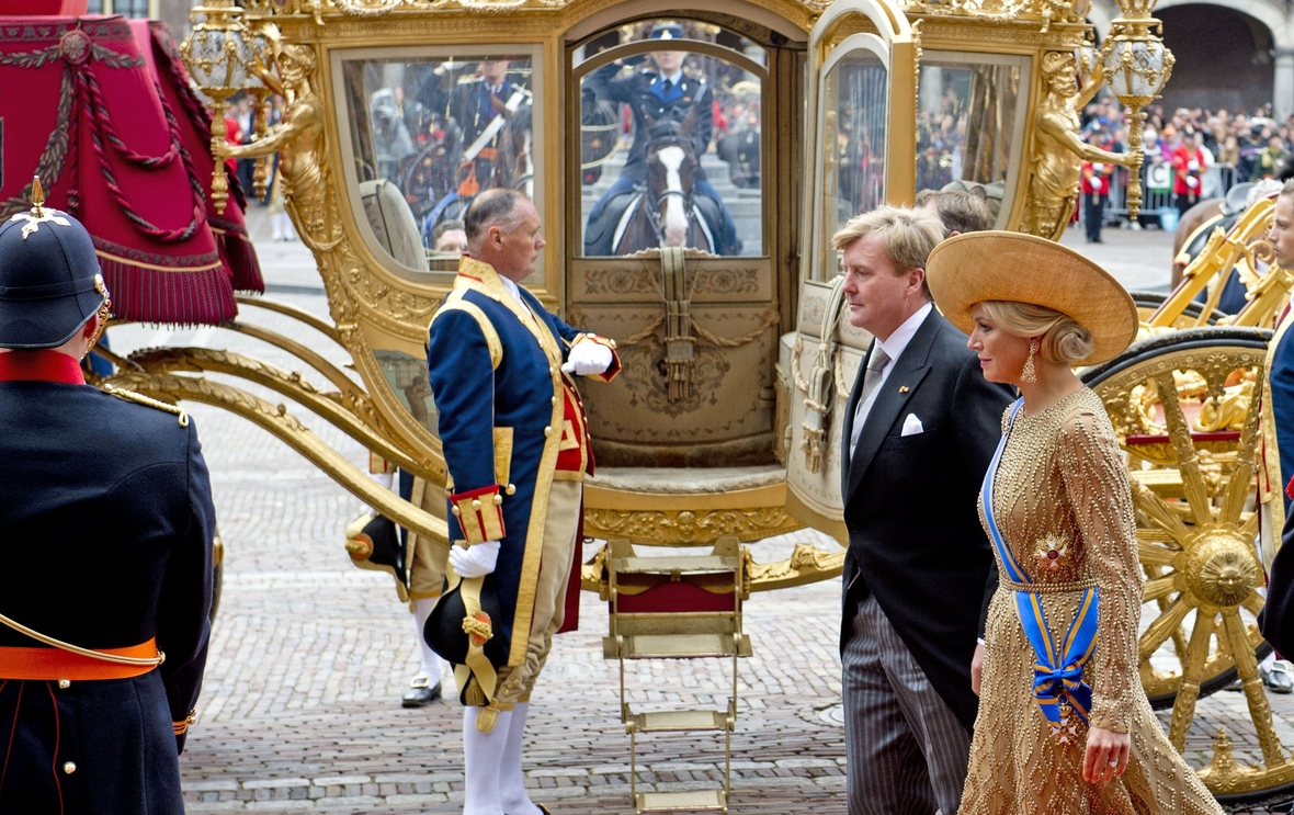 Das niederländische Königspaar: König Willem-Alexander und Maxima vor einer goldenen Kutsche.