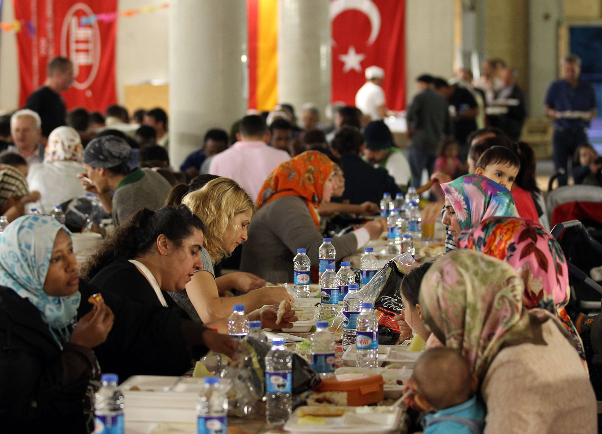 Am Ende des Fastenmonats Ramadan feiern die gläubige Muslime das "Fastenbrechen" wie hier in einer Kölner Moschee. Die Menschen speisen mit Freude und unterhalten sich.