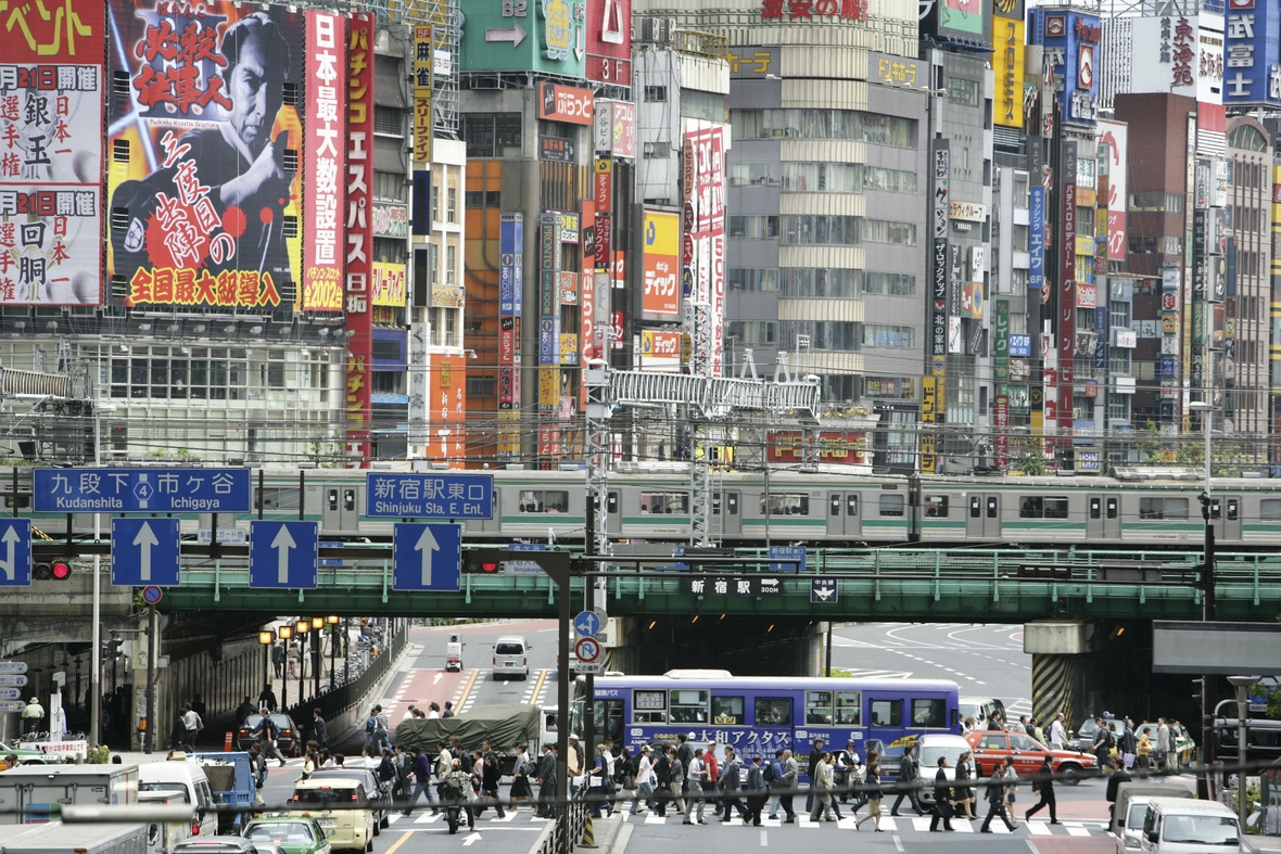 Japan, Tokio. Zu sehen ist der Stadtteil Shinjuku. Die Aufnahme zeigt die Ostseite des Shinkuku Bahnhofs, das Einkaufs- und Vergnügungsviertel an der Shinjuku Subnade Straße und Leuchtreklame.