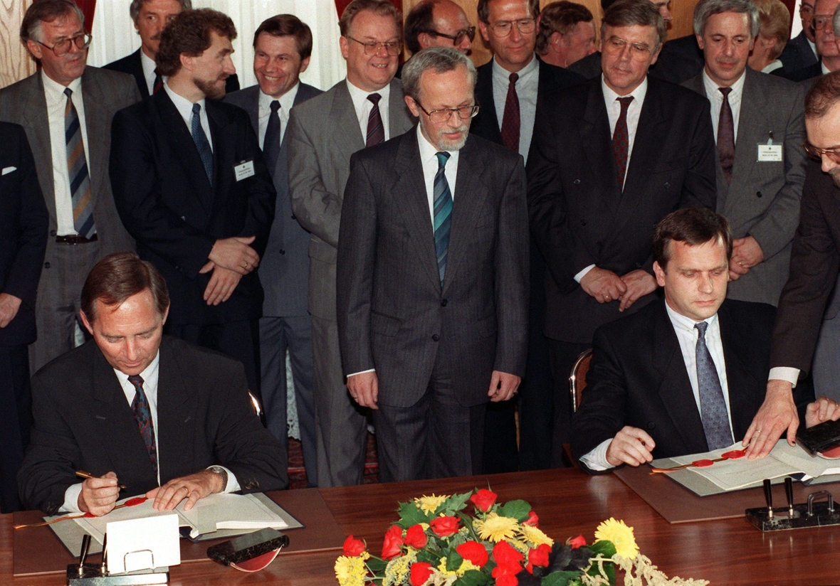 Bundesinnenminister Wolfgang Schäuble (l) und DDR-Staatssekretär Günther Krause bei der Unterzeichnung der Urkunden am 31. August 1990. In der Mitte DDR-Ministerpräsident Lothar de Maiziere. Im Palais Unter den Linden in Berlin besiegelten am 31. August 1990 die Regierungen beider deutscher Staaten den Beitritt der DDR zur Bundesrepublik am 3. Oktober 1990.