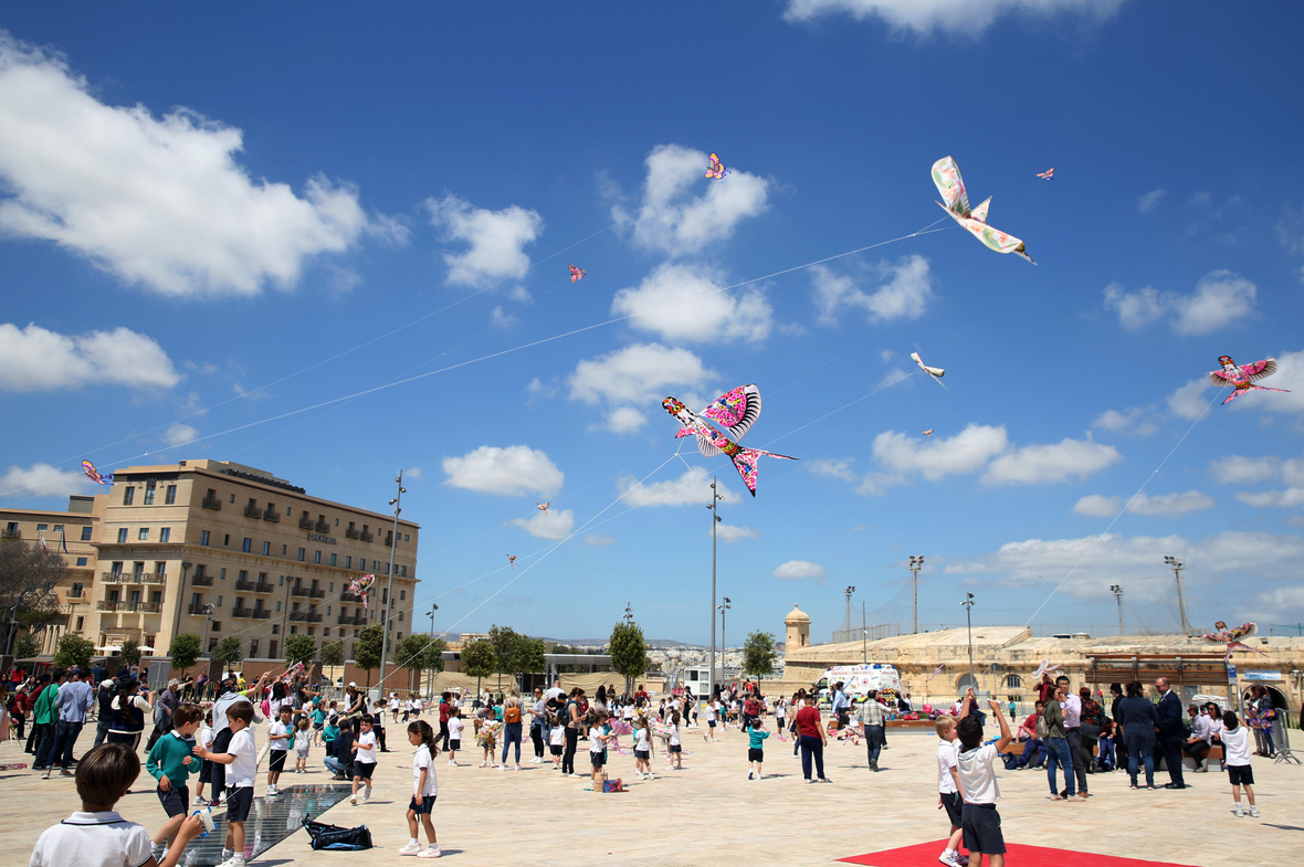 Kinder haben Spaß beim Drachenfliegen während des chinesischen Drachenfestivals in Valleta, der Hauptstadt Maltas. Bunte chinesische Drachen schmücken den blauen Himmel über der Stadt.