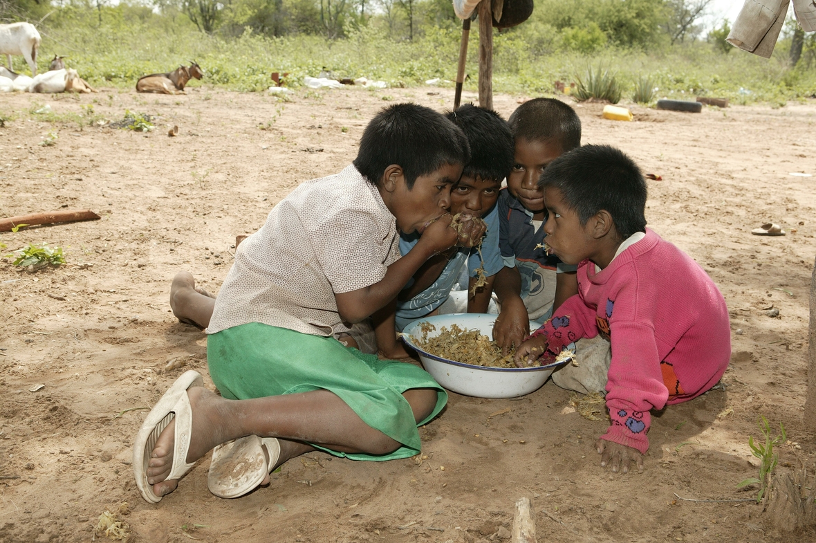 Kinder vom Stamm der Nivaclé-Indianer essen frisches, zerkleinertes Zuckerrohr in der Region Chaco in Paraguay.