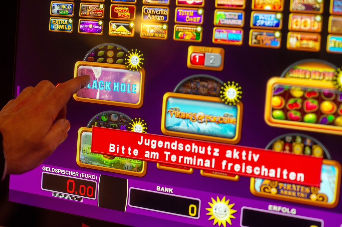 "Jugendschutz aktiv" und "Bitte am Terminal freischalten" steht auf dem Bildschirm eines Glücksspielautomaten.