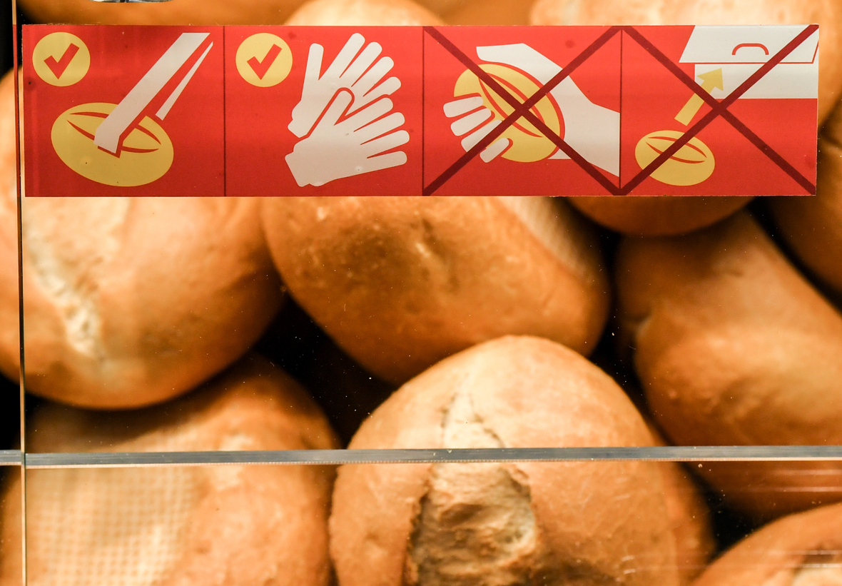 Bei dem Verkauf von Lebensmitteln gibt es Hygiene-Regeln, die unbedingt eingehalten werden müssen: So dürfen frisch aufgebackene Brötchen im Supermarkt nur mit einer Backwarenzange oder Einweg-Handschuhen angefasst werden. Nach dem Anfassen dürfen die Backwaren nicht mehr zurückgelegt werden. Darauf weist das Schild hin.