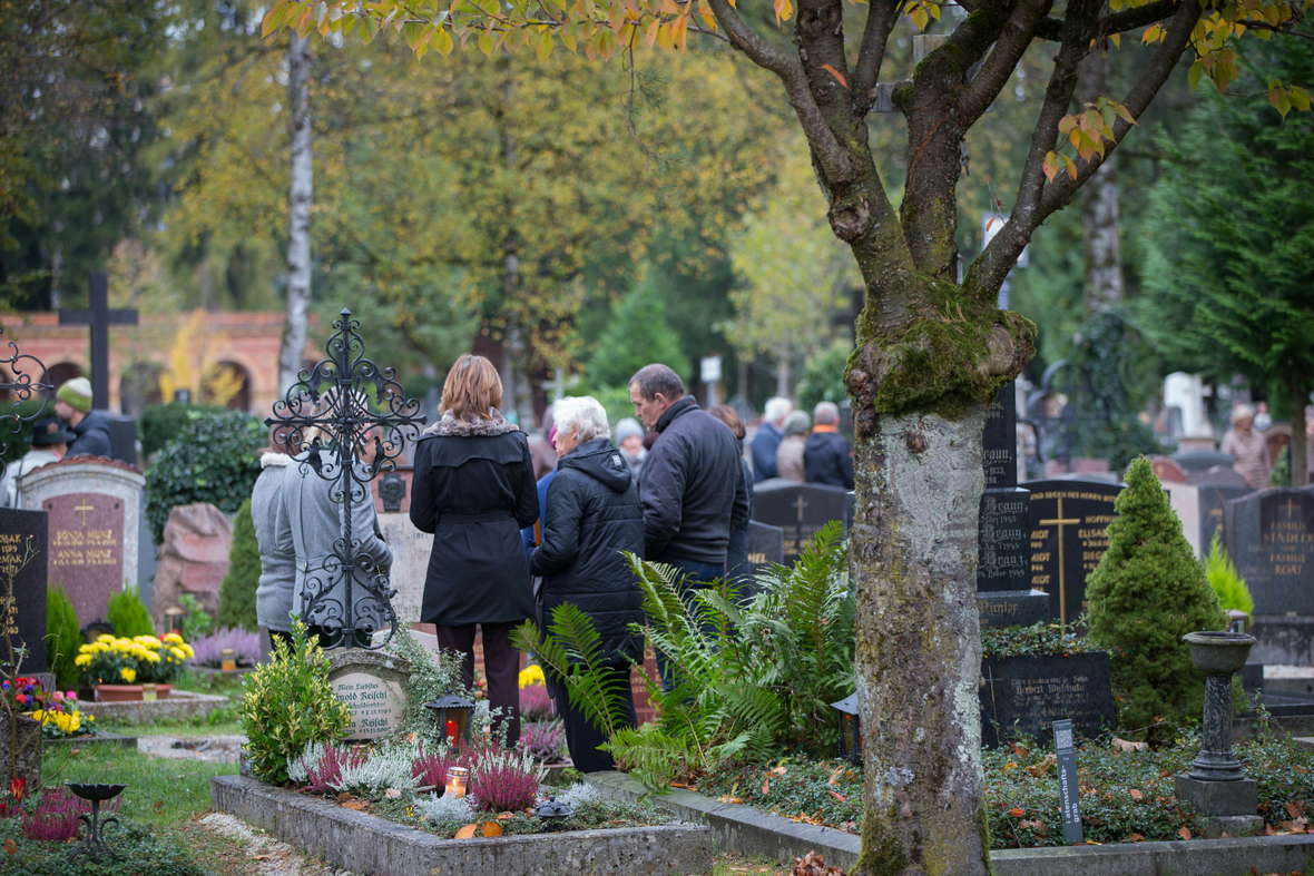 Österreich: Familie besucht an Allerheiligen einen Friedhof und gedenkt der Verstorbenen