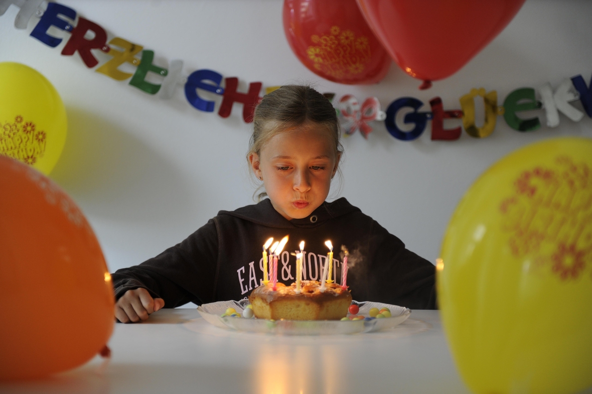 Kindergeburtstag eines acht Jahre alten Mädchens mit Geburtstagskuchen, Luftballons und Dekoration
