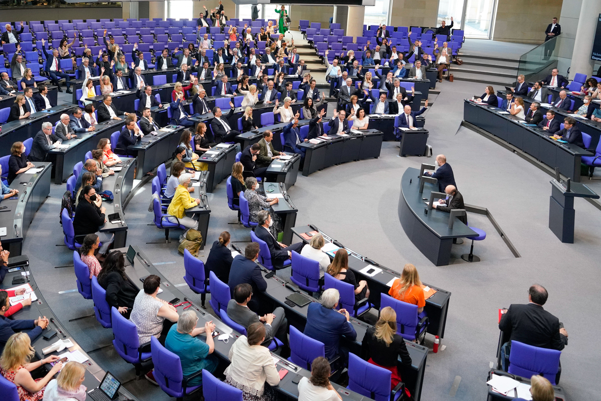 Abgeordnete sitzen im Plenum des Deutschen Bundestages. Es findet eine Abstimmung per Armheben statt. 